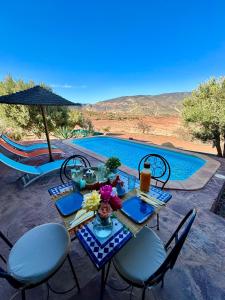 a table and chairs next to a swimming pool at Soo Bin in Bine el Ouidane