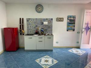 a kitchen with a red refrigerator and a tile floor at Il Nido del Gabbiano in Procida