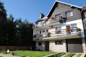 a large white building with flower boxes on the balconies at Róża in Szklarska Poręba