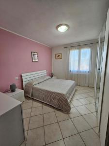 a bedroom with a bed and a pink wall at Villa Marta in Città della Pieve