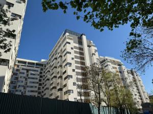 a tall white building with trees in front of it at Bucharest Premium Luxury Studios & Apartments by Glam Story in Bucharest