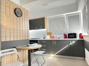 a kitchen with a table and a clock on the wall at Bucharest Premium Luxury Studios & Apartments by Glam Story in Bucharest