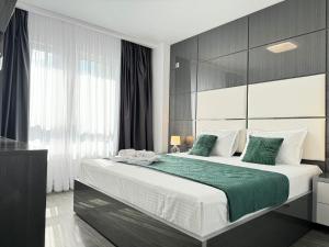 a bedroom with a large bed with green sheets at Bucharest Premium Luxury Studios & Apartments by Glam Story in Bucharest