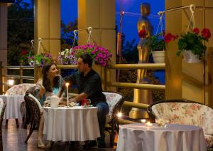 a man and woman sitting at tables in a restaurant at Oscar in Truskavets