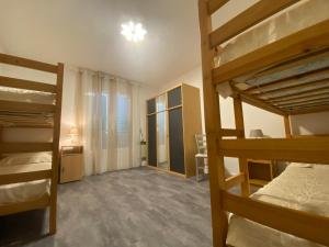 a room with two bunk beds and a bedroom with a window at Résidence LO MONACO Haut de villa, Appartements et Studios in San-Nicolao