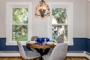 a dining room table with chairs and a chandelier at The Maisonette by Corbitt Hospitality in Annapolis Royal
