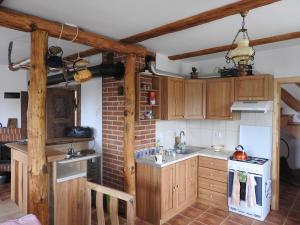 a kitchen with wooden cabinets and a stove top oven at Agroturystyka Biebrzańska Kraina in Pluty