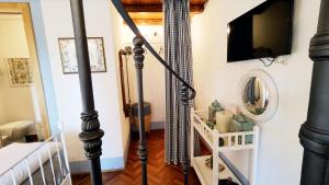 a room with a staircase with a television on a wall at Escape to Comfort, Relax, and Love in Rome - Luxury Agriturismo 5 Suites in La Giustiniana
