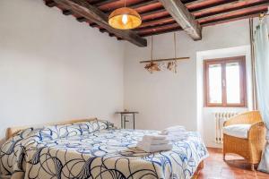 a bedroom with a bed and a chair and a window at Camera a Casa Castora in Uffogliano
