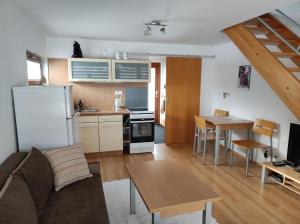a kitchen and living room with a couch and a table at Apartmán v Bečva Resortu in Horní Bečva