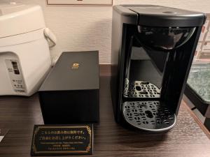 a coffee maker and a phone in a box on a table at ホテル リズコート HOTEL Liz court in Sendai