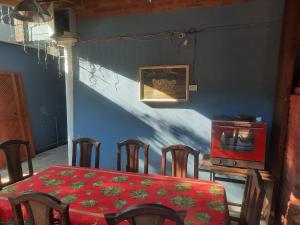 a dining room with a red table and chairs and a table and a red table at La Posada de Dante in Puerto Iguazú