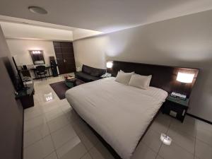 a bedroom with a large bed and a living room at ホテル リズコート HOTEL Liz court in Sendai
