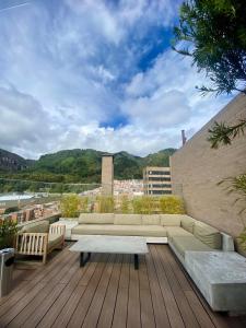 a rooftop patio with a couch and a table at Loft en Bogota Centro Internacional in Bogotá