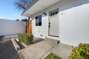 a white house with a door and a fence at Brand New Apt W Parking Blocks From Downtown- F in Sunnyvale