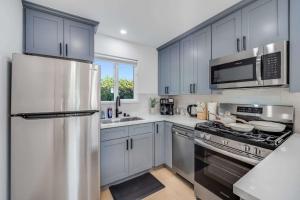 a kitchen with a stainless steel refrigerator and a sink at Brand New Apt W Parking Blocks From Downtown- D in Sunnyvale