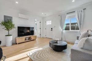 a living room with a couch and a tv at Brand New Apt W Parking Blocks From Downtown- D in Sunnyvale
