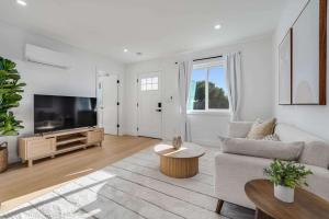a living room with a couch and a flat screen tv at Brand New Apt W Parking Blocks From Downtown- C in Sunnyvale