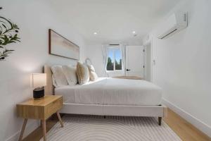 a white bedroom with a bed and a window at Brand New Apt W Parking Blocks From Downtown- C in Sunnyvale