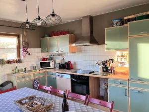 a kitchen with a table and chairs in it at Les Pierris in La-Roche-en-Ardenne