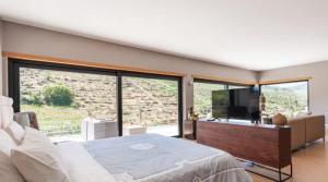 a bedroom with a bed and a large window at Amazing Villa in Douro Valley - Pool in Espinhosa +36 photos