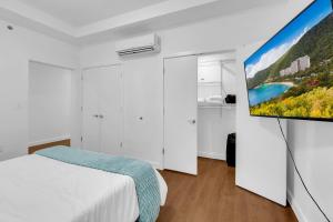 a bedroom with a bed and a flat screen tv at Sleek 1BR Near BOKCenter-Gym,Lounge,Balcony,PetOK in Tulsa +67 photos
