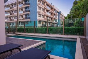 a swimming pool in front of a apartment building at Apartamento Exclusivo a 600m da Praia de Palmas Piscina Banheira de Imersão aquecida rede in Governador Celso Ramos