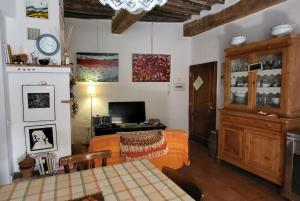 a living room with a bed and a television at La Casa Di Dina in Castelmuzio