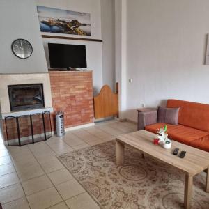 a living room with a couch and a fireplace at Adi's House in Kalamitsi +6 photos