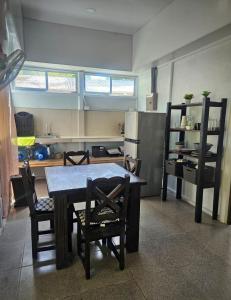 a kitchen with a table and chairs and a refrigerator at Casa Javillo Rustika in Puerto Limón