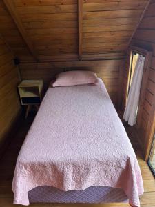 a bedroom with a bed in a wooden cabin at Pousada Chalé Flor de Hibisco 3 in Penha +24 photos