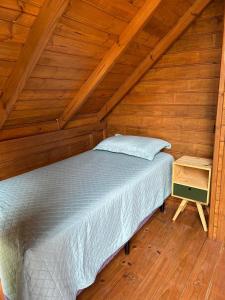 a bed in a room with a wooden ceiling at Pousada Chalé Flor de Hibisco 3 in Penha
