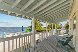 uma varanda com um banco e cadeiras na praia em Parmer's Resort em Little Torch Key