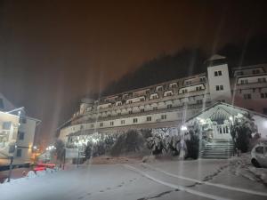 ein großes Gebäude im Schnee bei Nacht in der Unterkunft Apartman Dasha in Brzeće