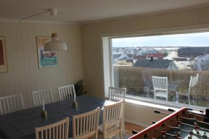 a dining room with a table and chairs and a large window at Ocean panorama in Farsund