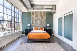 a bedroom with a bed in a room with windows at DTLA 2BR Rooftop Jacuzzi & Sunset Views in Los Angeles +48 photos