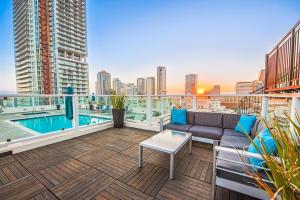 a balcony with a couch and a pool on a building at DTLA 2BR Rooftop Jacuzzi & Sunset Views in Los Angeles