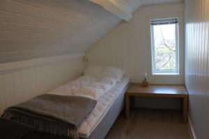 a large bed in a room with a window at Ocean panorama in Farsund