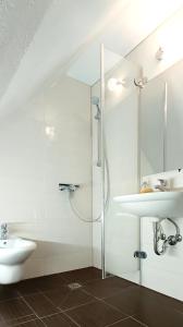 a white bathroom with a sink and a shower at Ferienwohnung Michelle mit Balkon für 1 - 6 Personen in Warmensteinach