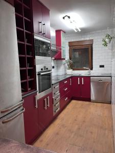 LozoyuelaにあるCasa de la ermitaのウッドフロアのキッチン(赤いキャビネット付)