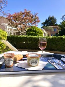 a tray with a glass of wine and a plate of food at Hôtel Jas Neuf in Sainte-Maxime