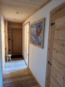 a hallway with a door and a painting on the wall at Logis Hôtels de la Chaussée in Briançon