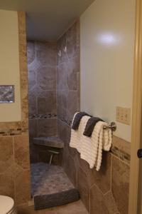 a bathroom with a shower with a toilet and towels at Harvest House Bed and Breakfast in Springdale +26 photos