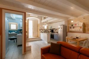Una sala de estar con un sofá y una cocina. en Sassi SediciDiciotto, en Matera