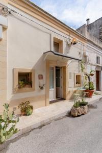 Una casa blanca con macetas al costado. en Sassi SediciDiciotto, en Matera