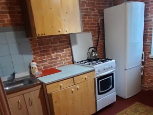 a kitchen with a stove and a white refrigerator at Эконом вариант - спальный район in Chernihiv +7 photos