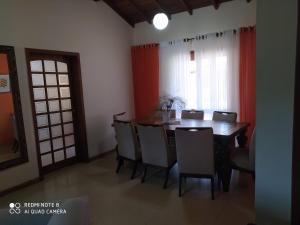 Un comedor con mesa y sillas y una ventana. en Casa confortável, en Pelotas