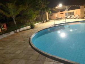a large blue swimming pool at night at Quarto acolhedor in Aracaju