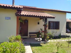 una casa con un banco delante de ella en Casa confortável, en Pelotas