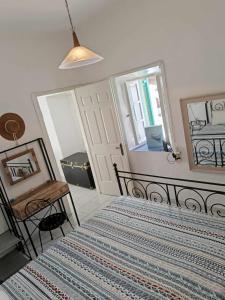 a bedroom with a bed and a table and a mirror at Lipsi Eirini s Home in Lipsoi